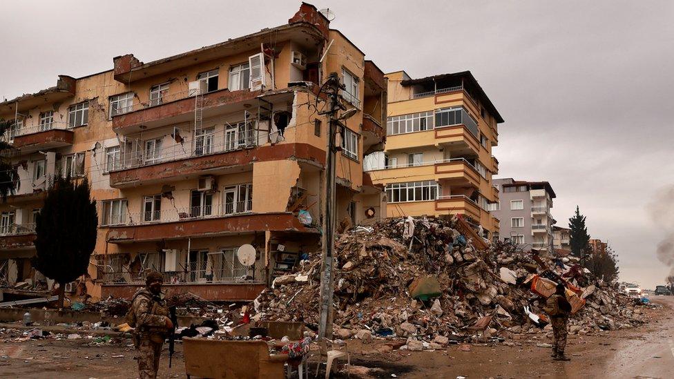 Turkish army members stand guard near destroyed properties in the aftermath of the deadly earthquake in Antakya, Hatay province