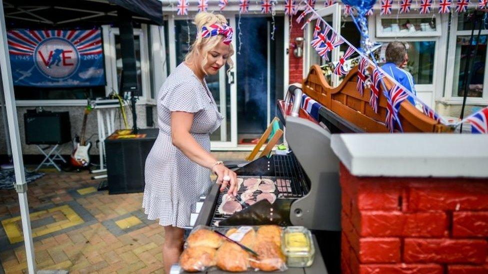 Laura Stacey turns bacon on the BBQ outside her home on Novers Park Road, Knowle, Bristol, on VE Day earlier in May 2020