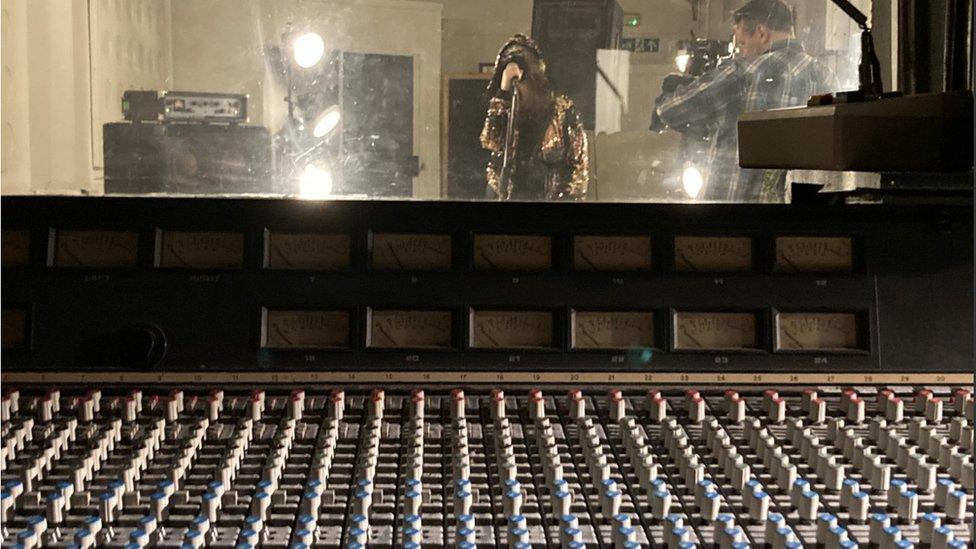 View from the mixing desk of B of Briz performing in the studio while being filmed