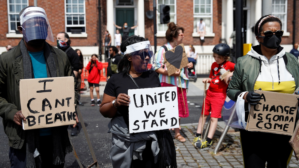 Demonstrators hold placards