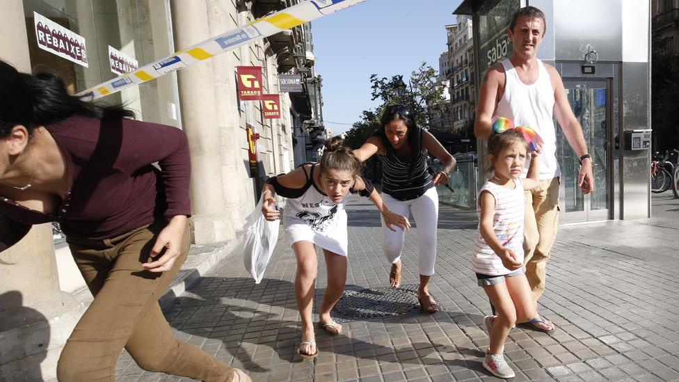 People leave a cordoned off area after a van ploughed into the crowd, killing one person and injuring several others on the Rambla in Barcelona on August 17, 2017.