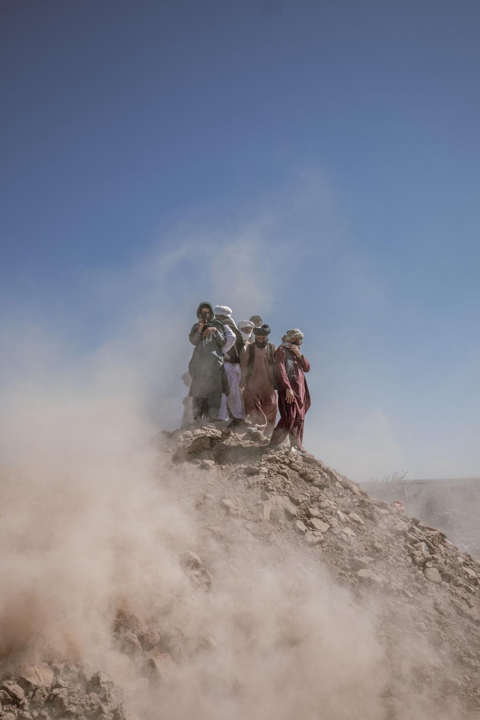 In the wake of the powerful 6.3 magnitude earthquake that struck Herat, a group of Afghans congregates on a mound of rubble, their gaze fixed on the scene as they assess the disaster's impact. 10 October 2023