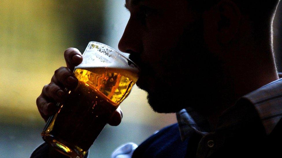 A man drinks a pint of lager, in the Coach and Horses pub in Farringdon, London