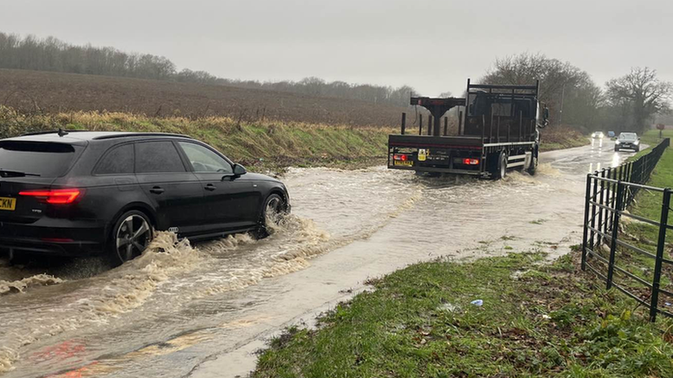 Vehicles driving through a flood