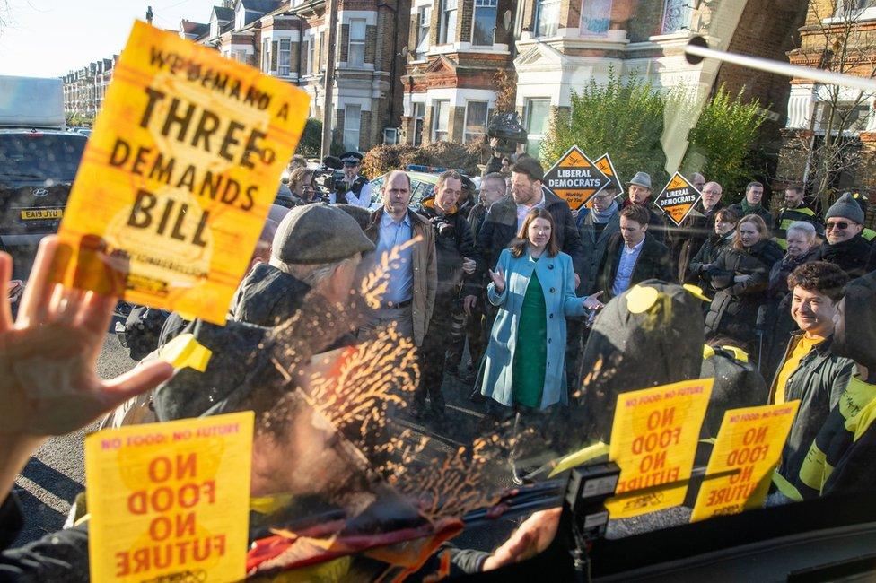 Jo Swinson speaks to Extinction Rebellion protesters dressed as bees glued to a bus