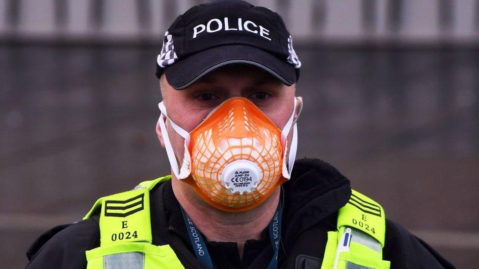 A police officer wears a PPE face mask outside the Scottish Parliament as members of the public attend an anti lockdown protest held by The Scotland Against Lockdown group in Edinburgh, Scotland on January 11, 2021.