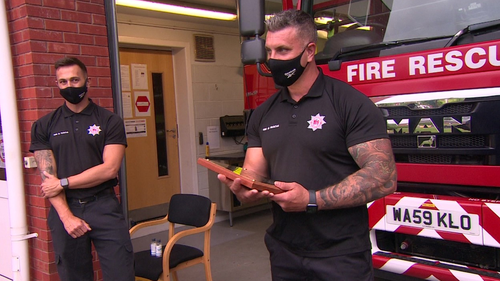 Two firefighters with plaque