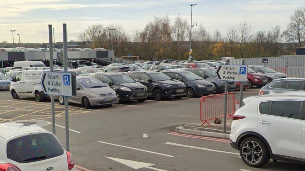 Full car park with "patient and visitor parking" signs