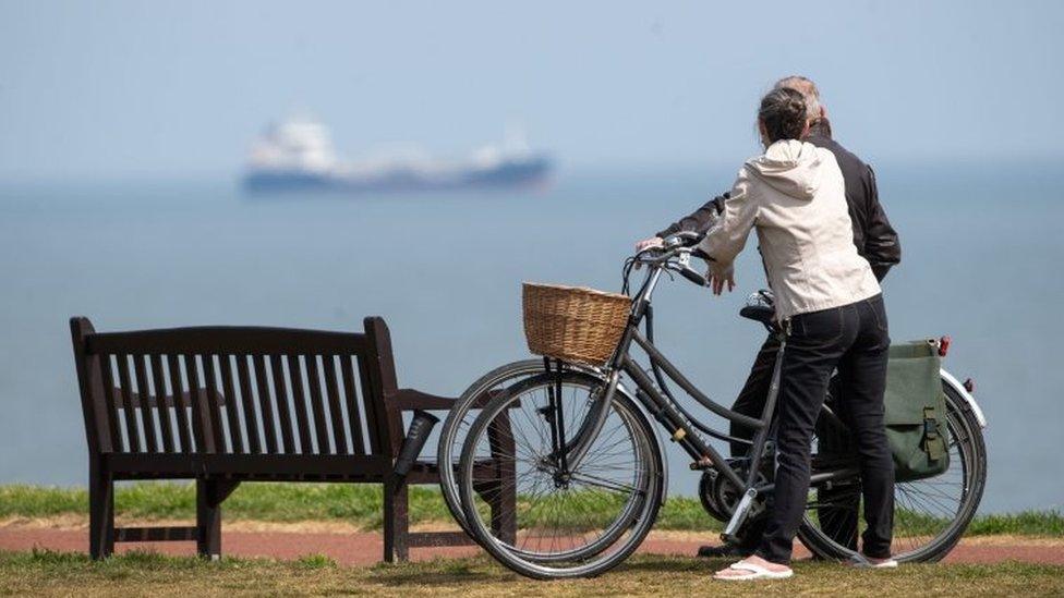 People take a break in their daily exercise at Gorleston-on-Sea in Norfolk as the UK continues in lockdown