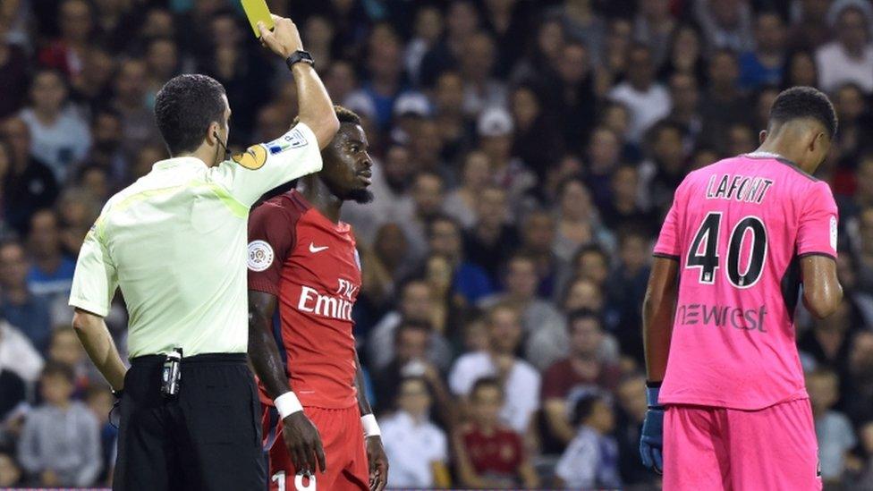 Paris Saint-Germain's Ivorian defender Serge Aurier (2nd L) receives a yellow card by French referee Franck Schneider during the French L1 football match between Toulouse (TFC) and Paris Saint-Germain (PSG) on 23 September 2016