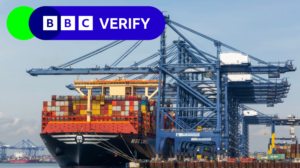 A very large container ship docked by blue cranes at the Port of Felixstowe. The BBC Verify logo is in the top left corner of the image.