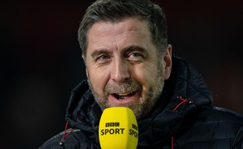 Mark Chapman holding a BBC Sport microphone in an outdoors coat before the Premier League match between Sheffield United and Manchester United at Bramall Lane on November 24, 2019