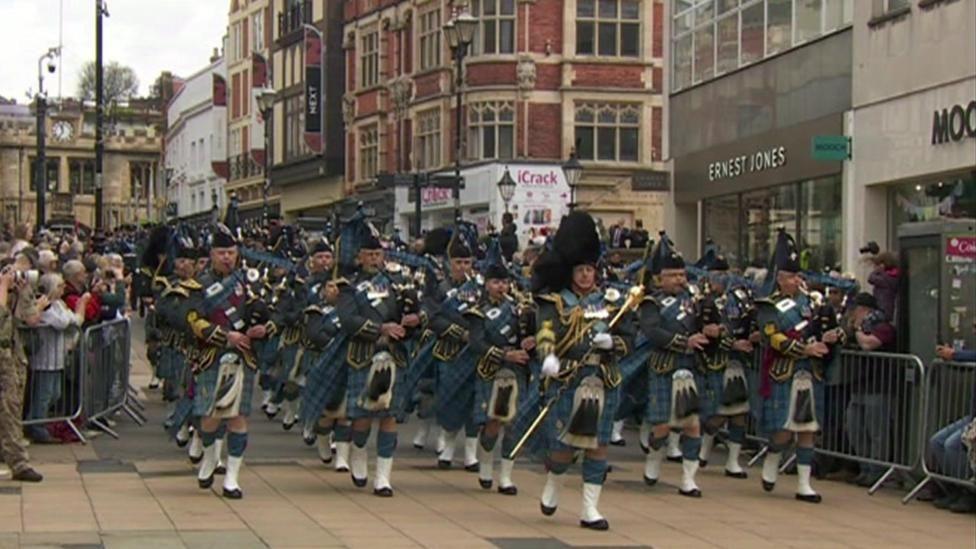 A marching band leads the way for a parade of RAF personnel in Lincoln.
