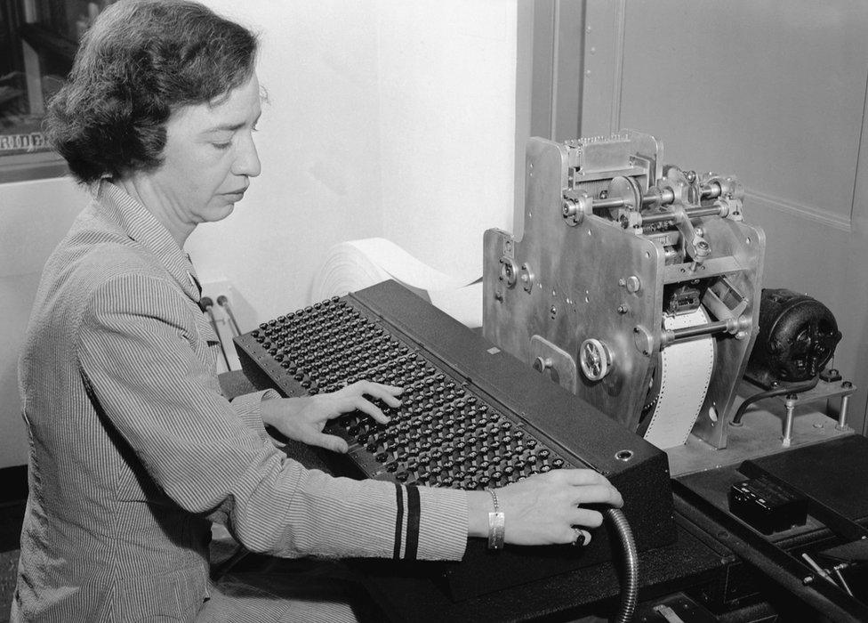 Lieutenant Grace Hopper uses a new calculating machine invented by Commander Howard H. Aiken for the Navy's use during WW1