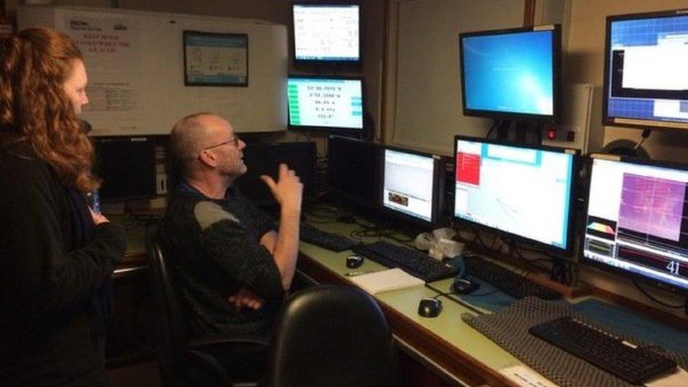 Boat crew monitor a bank of screens