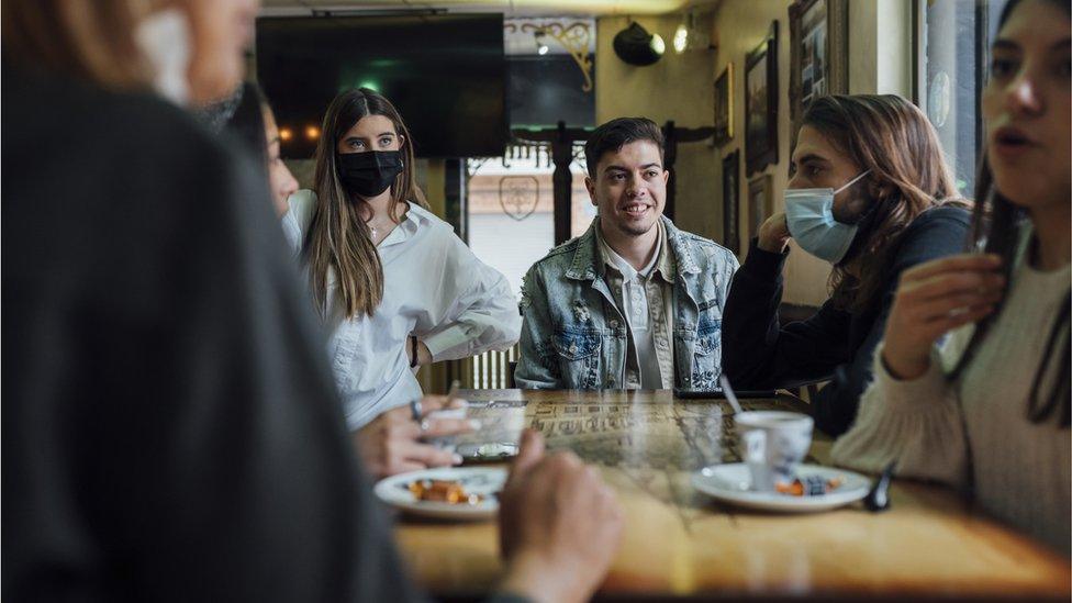 Group of young people sit around a table