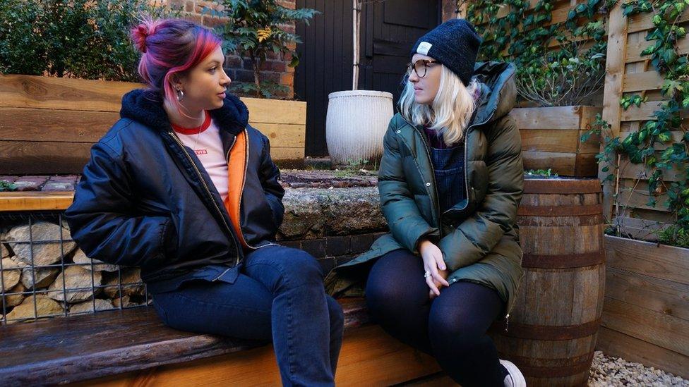 Two young women sat on bench