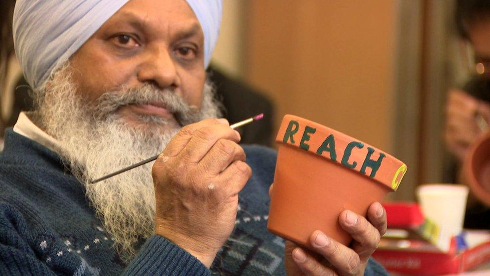 A Sikh man takes part in a painting exercise