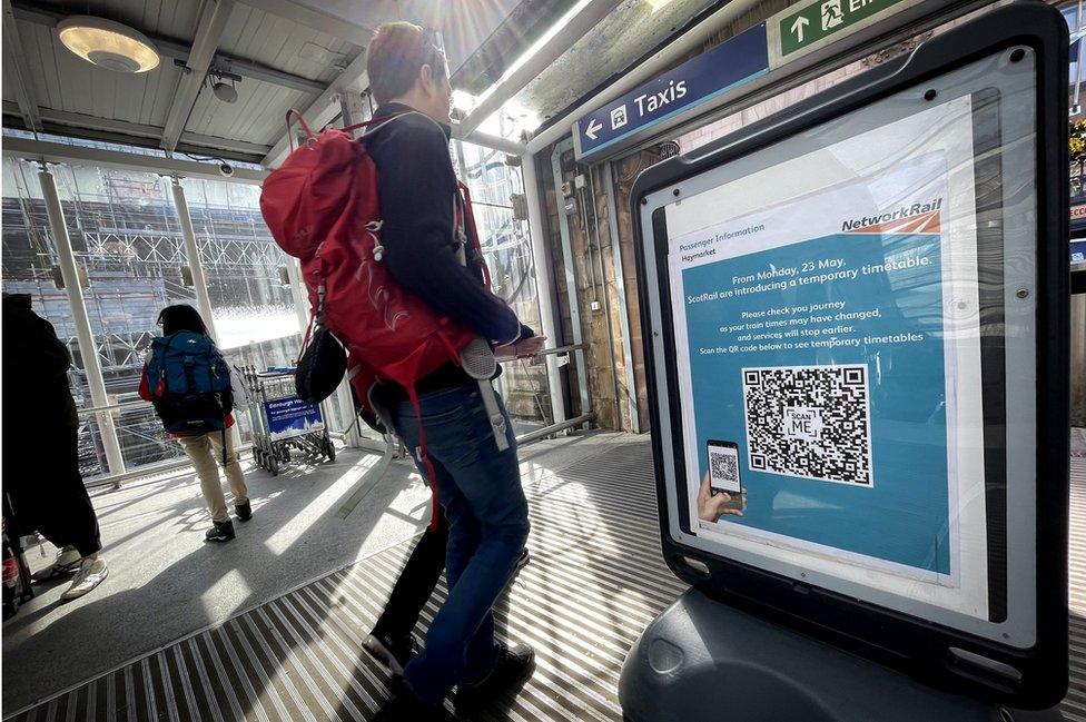 passenger looks at sign in Haymarket Station