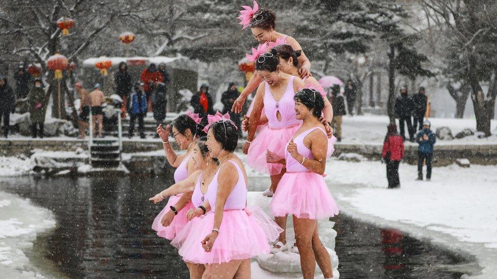 Swimmers laughing in the snow and pink tutus