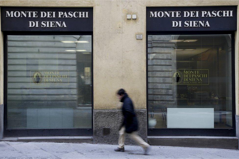 A man walks in front of the Monte dei Paschi bank in Siena, Italy.