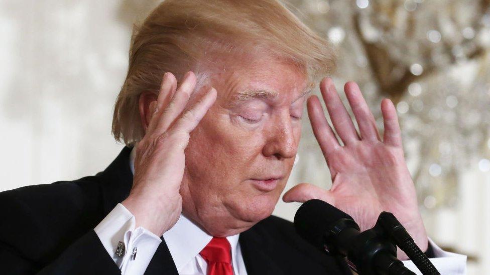 Donald Trump puts his hands to his head.