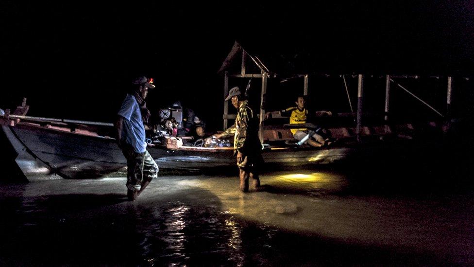 Members of Trapang Sangke community prepare their boat