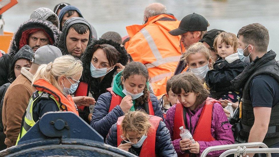 Picture shows people arriving in the UK off a boat, wearing life jackets