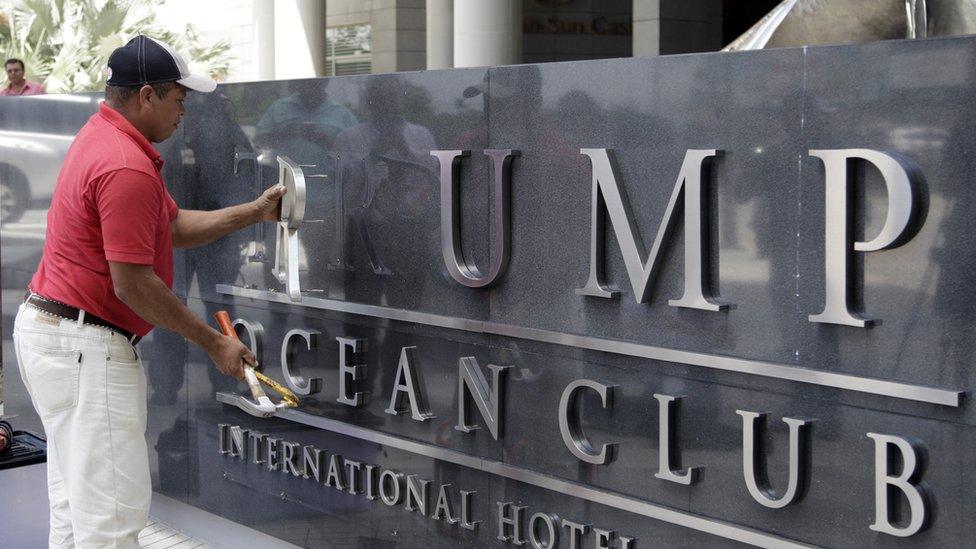 A worker removes the Trump sign letters from outside the hotel in Panama City on March 5, 2018