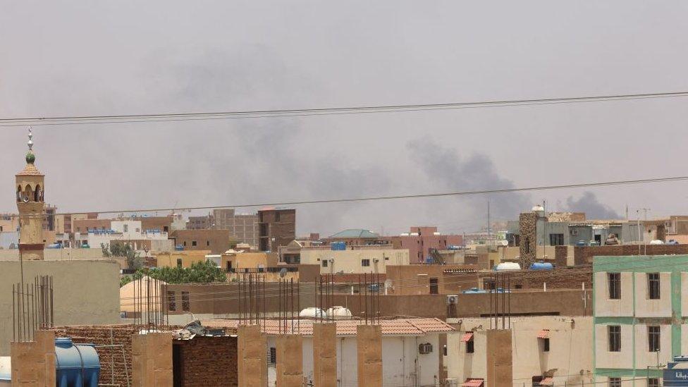 Smoke billows behind a mosque and residential buildings in eastern Khartoum on April 17, 2023, as fighting in Sudan raged for a third day in battles between the army and paramilitary forces. -