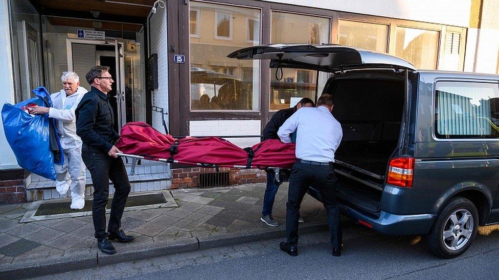 Undertakers carry a body on May 13, 2019 out of a house in Wittingen, northern Germany