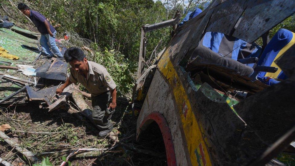 Neighbours and first responders inspect the area of a bus accident near Yolosita