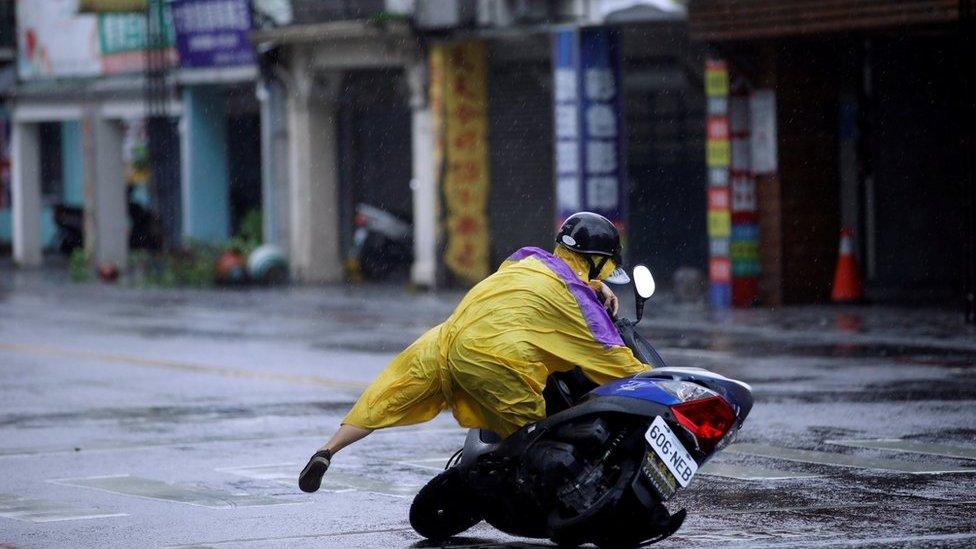 A motorcyclist falls off their bike as Typhoon Megi hits Hualien, eastern Taiwan, 27 September 2016.