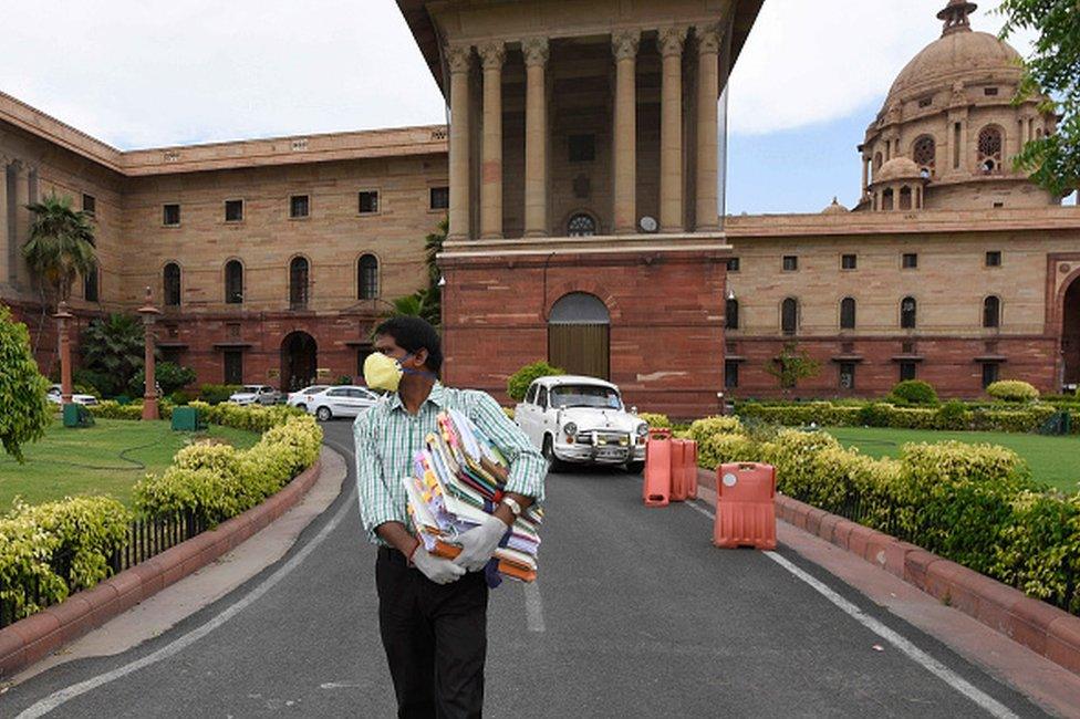 A government employee holding files as he comes out from Ministry of Finance at North Block as ministries and government offices partially resume working from office, at Raisina Hills on April 20, 2020 in New Delhi,