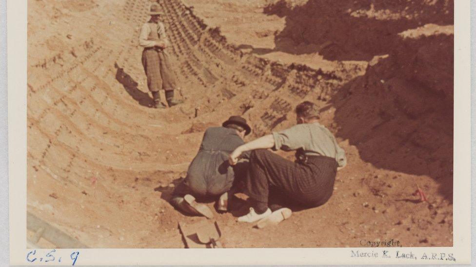 Lieutenant Commander Hutchison (left) and Charles Phillips (right) seated just beyond the burial chamber region and Basil Brown standing