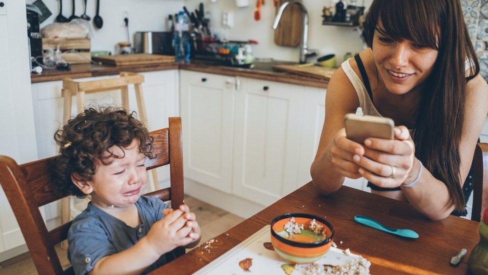 Image of child crying whilst mum is on phone