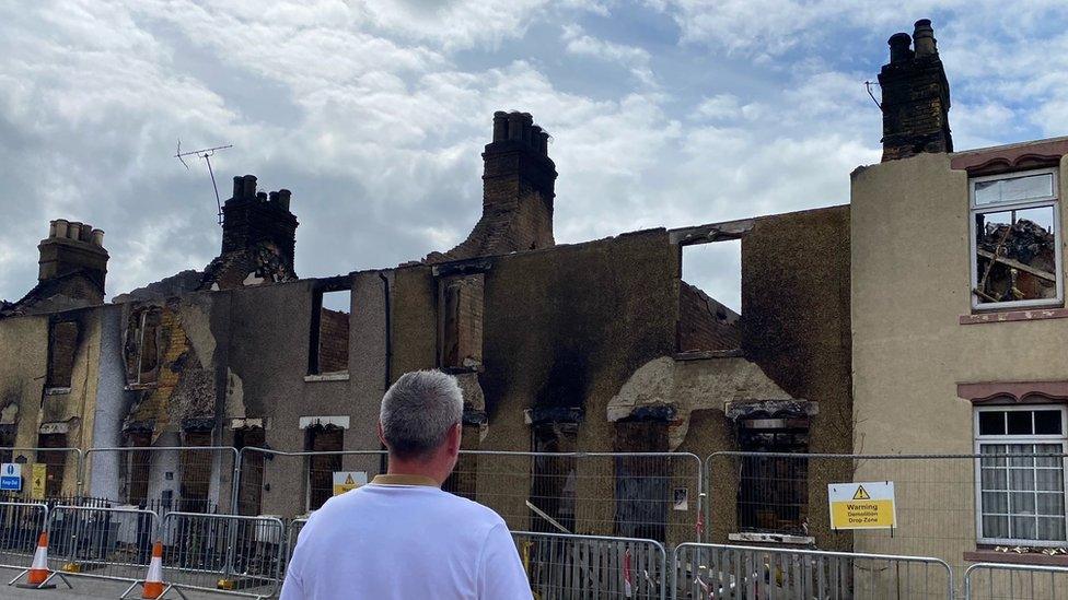 Michael Tubb looks at his fire destroyed family home