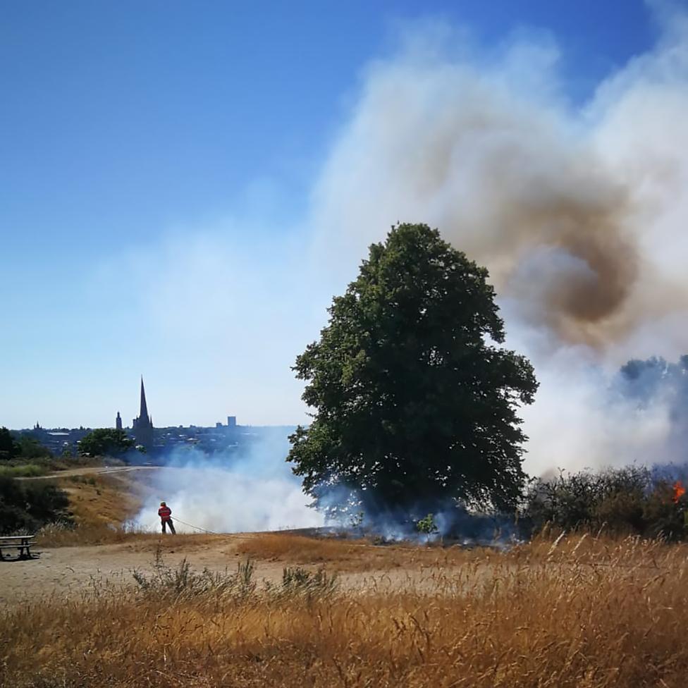 Fire and smoke on Mousehold Heath in Norwich with Norwich Cathedral seen in the distance