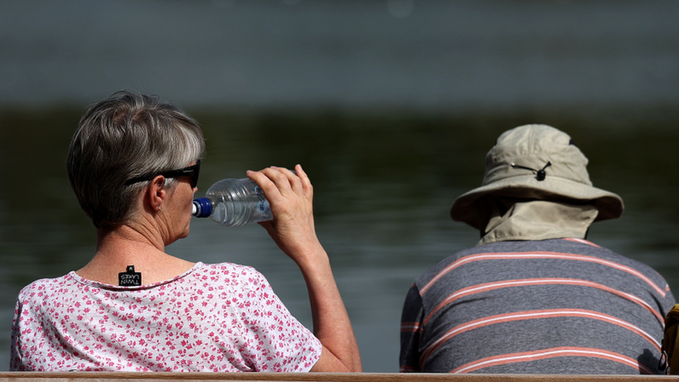 A couple sit on a bench at the Serpentine Lake at Hyde Park in London