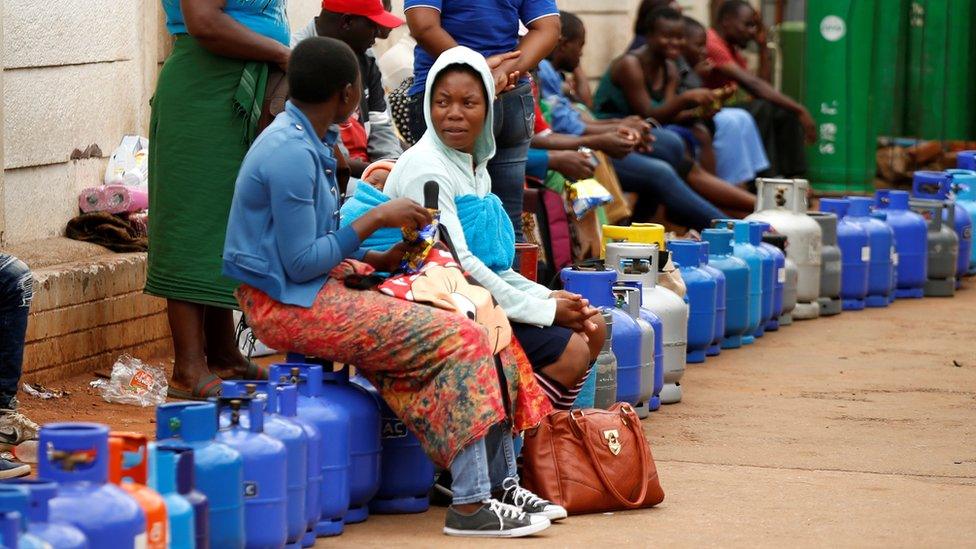 Two women queue for gas