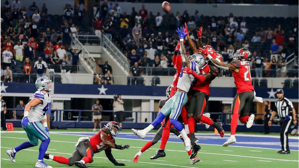 Dallas Cowboys players and Tampa Bay Buccaneers jump for a hail mary pass