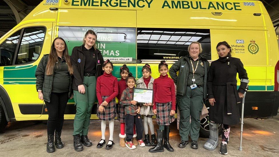 Kiran with her siblings, mother and emergency staff in front of an ambulance