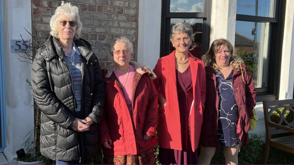 Modern day, four women stand outside 55 Percy Park