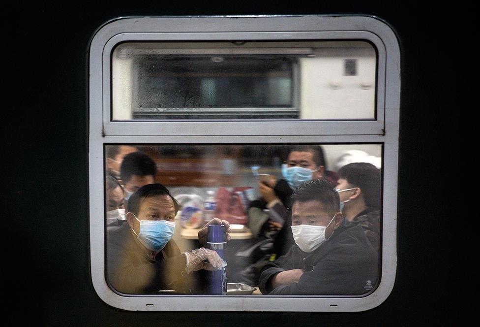 Passengers sit in a train carriage looking out the window