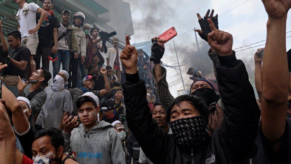 Indonesian men jeer at police during a clash in Jakarta on Wednesday