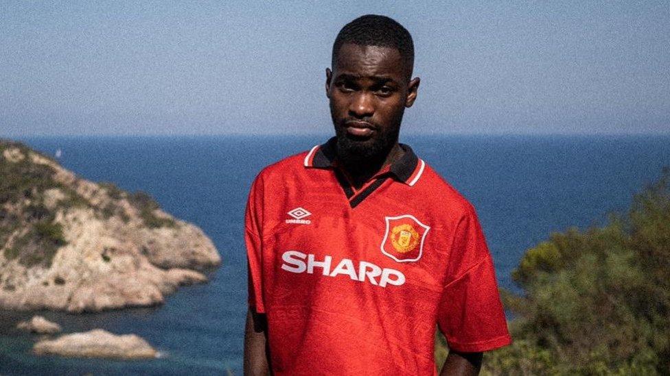 Santan Dave in Manchester United shirt.