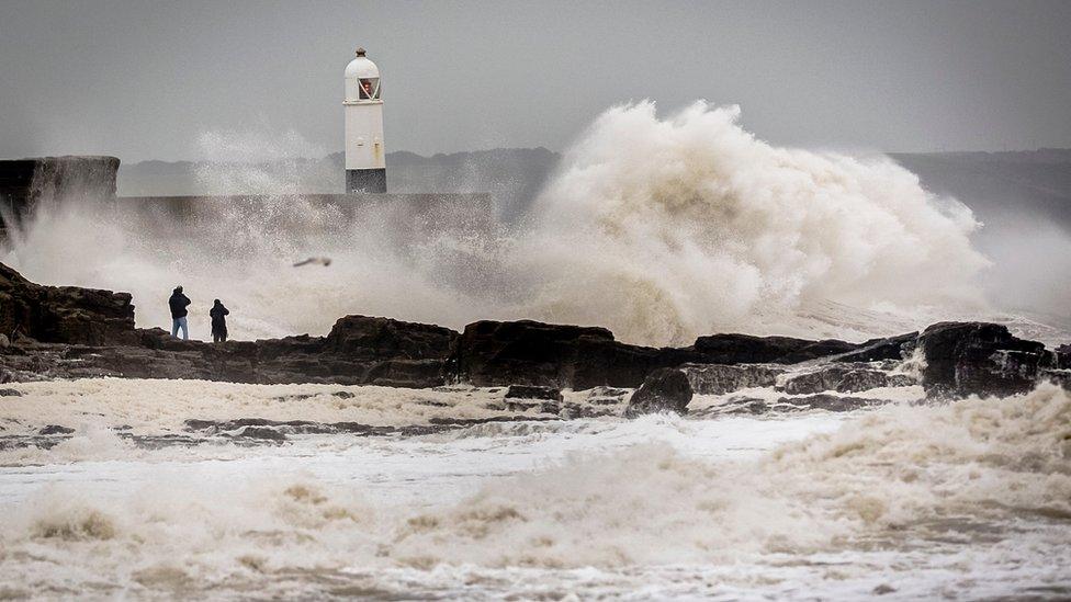 People watch waves close to the harbour wall at Porthcawl, South Wales, as Storm Desmond hit the UK on Saturday 5 December