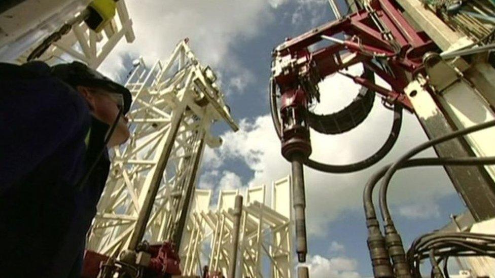 Man looking up at fracking equipment