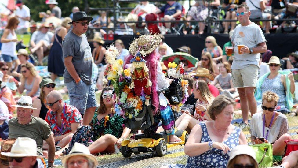 Festival goer drives through the crowd to get to her viewing position before Black Dylan perform on Day 2 of Cornbury Festival at Cornbury Festival on July 8, 2017