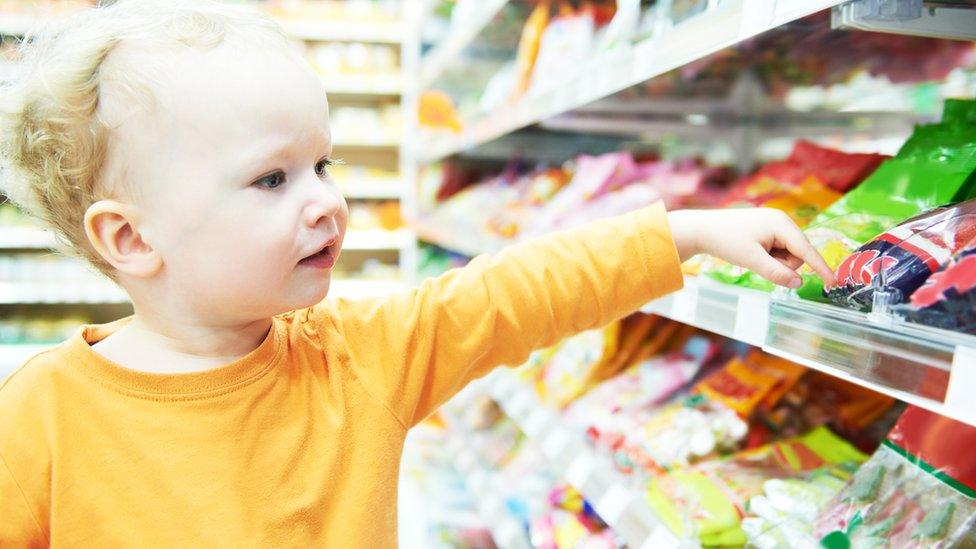 young boy reaching for sweets